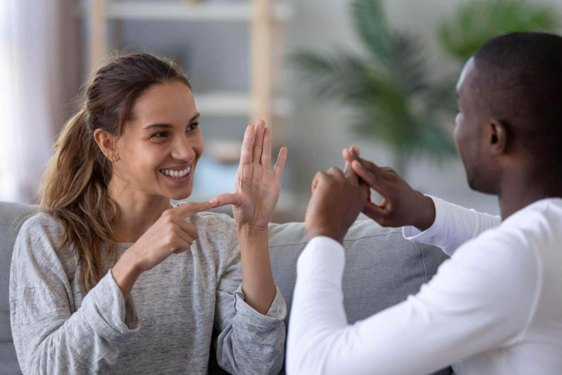 mixed ethnicity couple or interracial friends talking with sign finger hand language