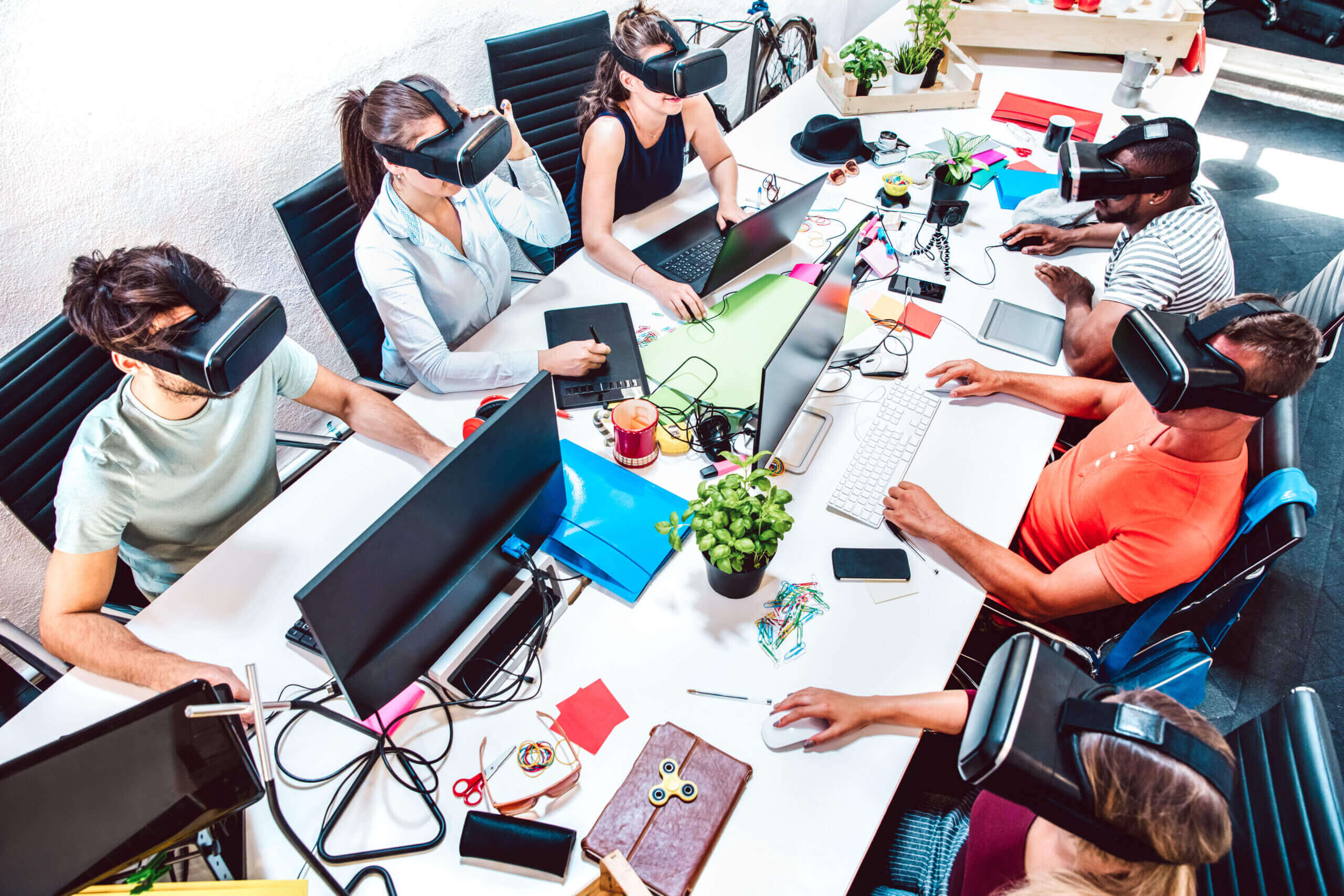 Group of employee workers concentrated on virtual reality goggles at startup studio