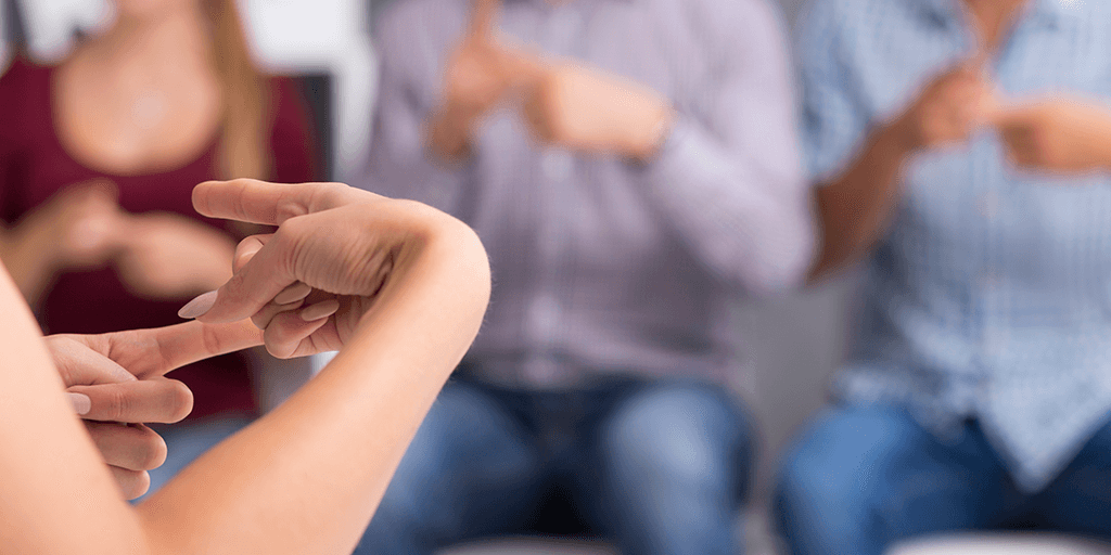 group of people signing in a sign language class