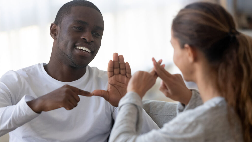 man and woman using sign language to communicate